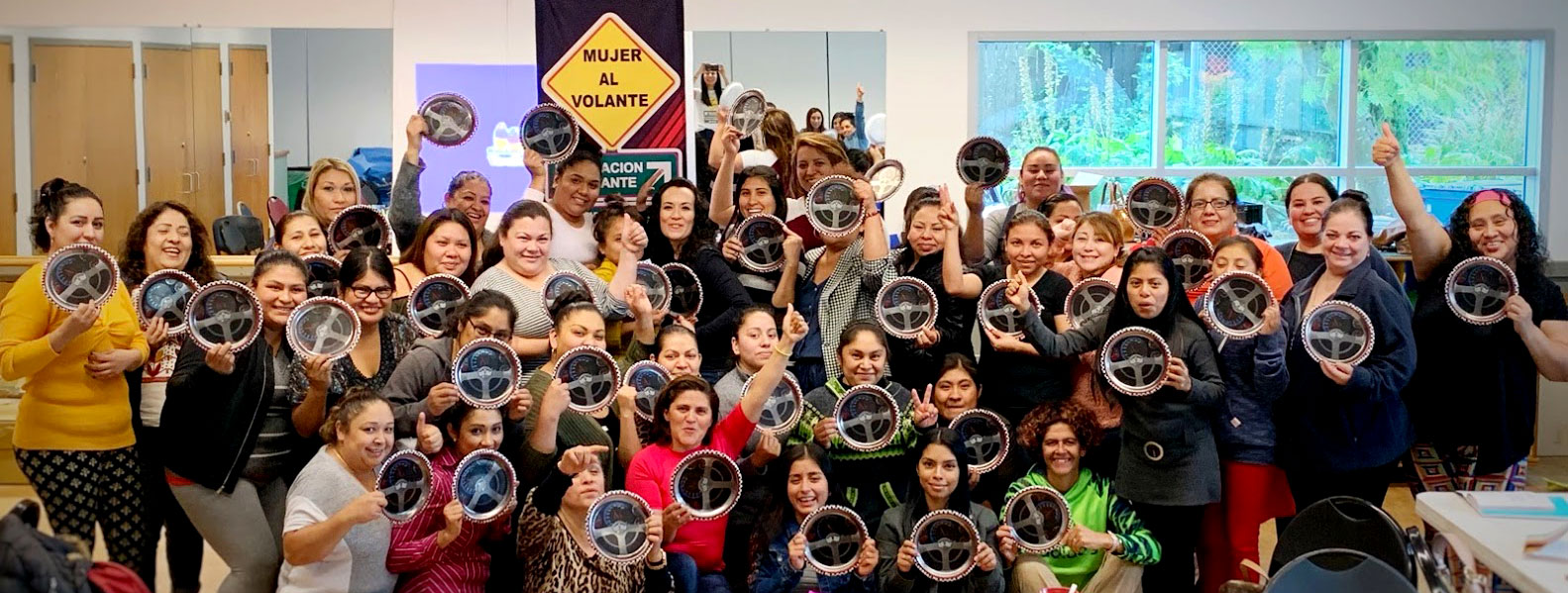 MAV participants holding steering wheels and smiling